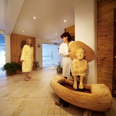 Zwei Gäste unterhalten sich im Wellnessbereich, sie haben gemütliche Bademäntel an. | © Hotel Eggerhof
