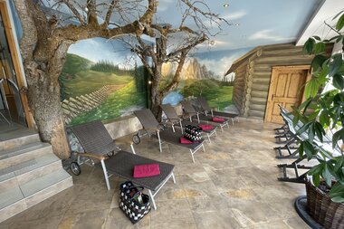 Ruheraum im Wellnessbereich mit Bäumen und gemütlichen Liegen. Auf der Wand ist eine Berglandschaft aufgemalt. | © Hotel Eggerhof