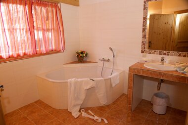 Helles, geräumiges Badezimmer mit einem Doppelwaschbecken und einer Badewanne | © Hotel Eggerhof