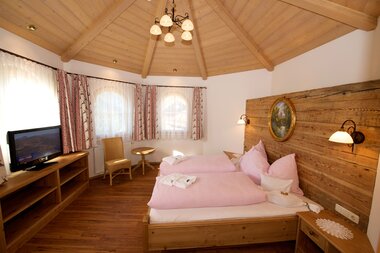 Helles Turmschlafzimmer mit einem Doppelbett | © Hotel Eggerhof