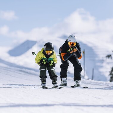 Zwei Skifahrer fahren um die Wette. Das Wetter ist herrlich. | © saalbach.com