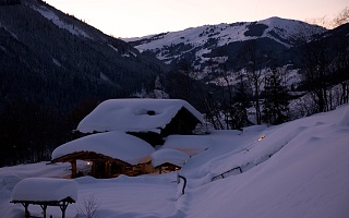 snow-covered alpine cabin at dawn